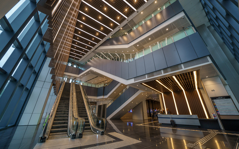 The main entrance provides a 3-storey height atrium space with highly transparent glass façade to maximise natural daylight while providing sun shading with vertical fins.